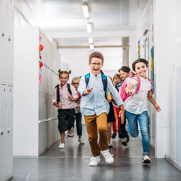 dzieci biegną na szkolnym korytarzu