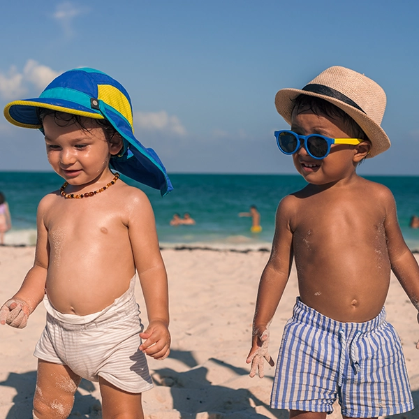 dzieci na plaży w kapeluszach i czapkach