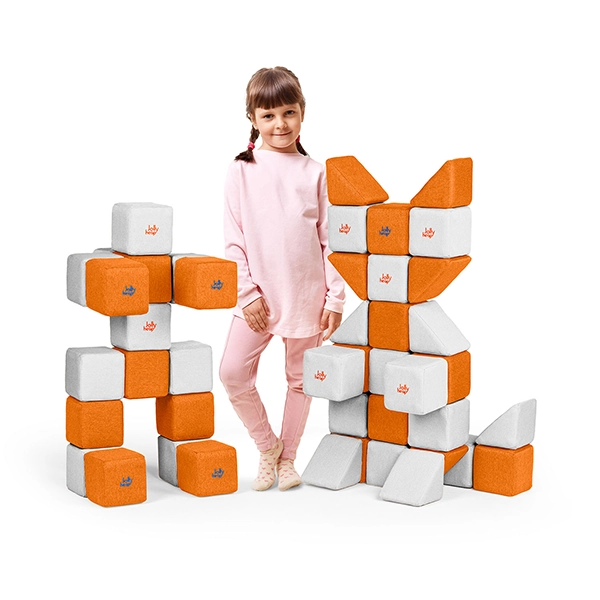 dziewczynka stoi obok magnetycznej układanki JollyHeap w biało-pomarańczowej kombinacji